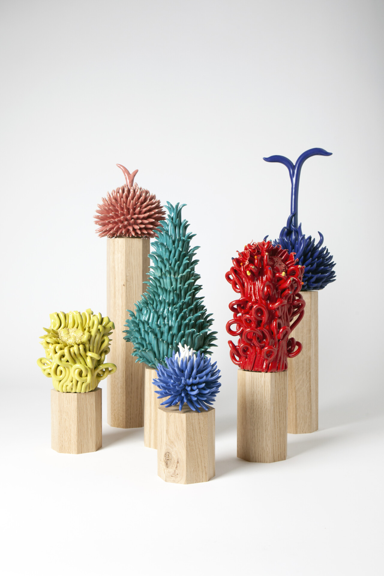 Ensembles de sculptures uniques de différentes couleurs, rouge, vert, jaune, bleu, inspirées des mondes végétaux en céramique par Jeanne Andrieu